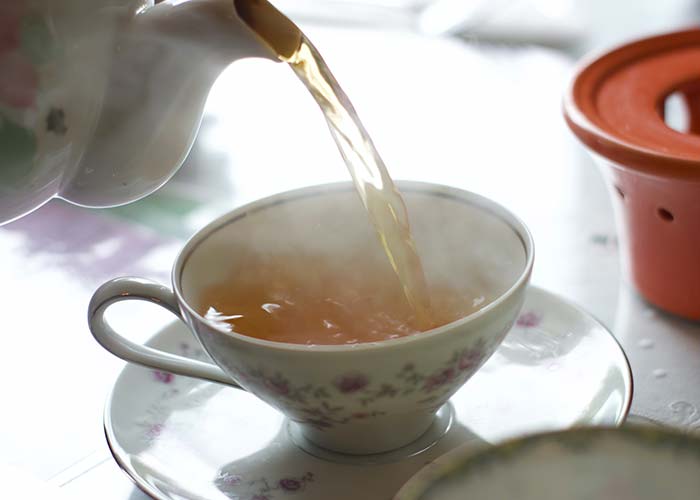 Close up of tea being poured into tea cup